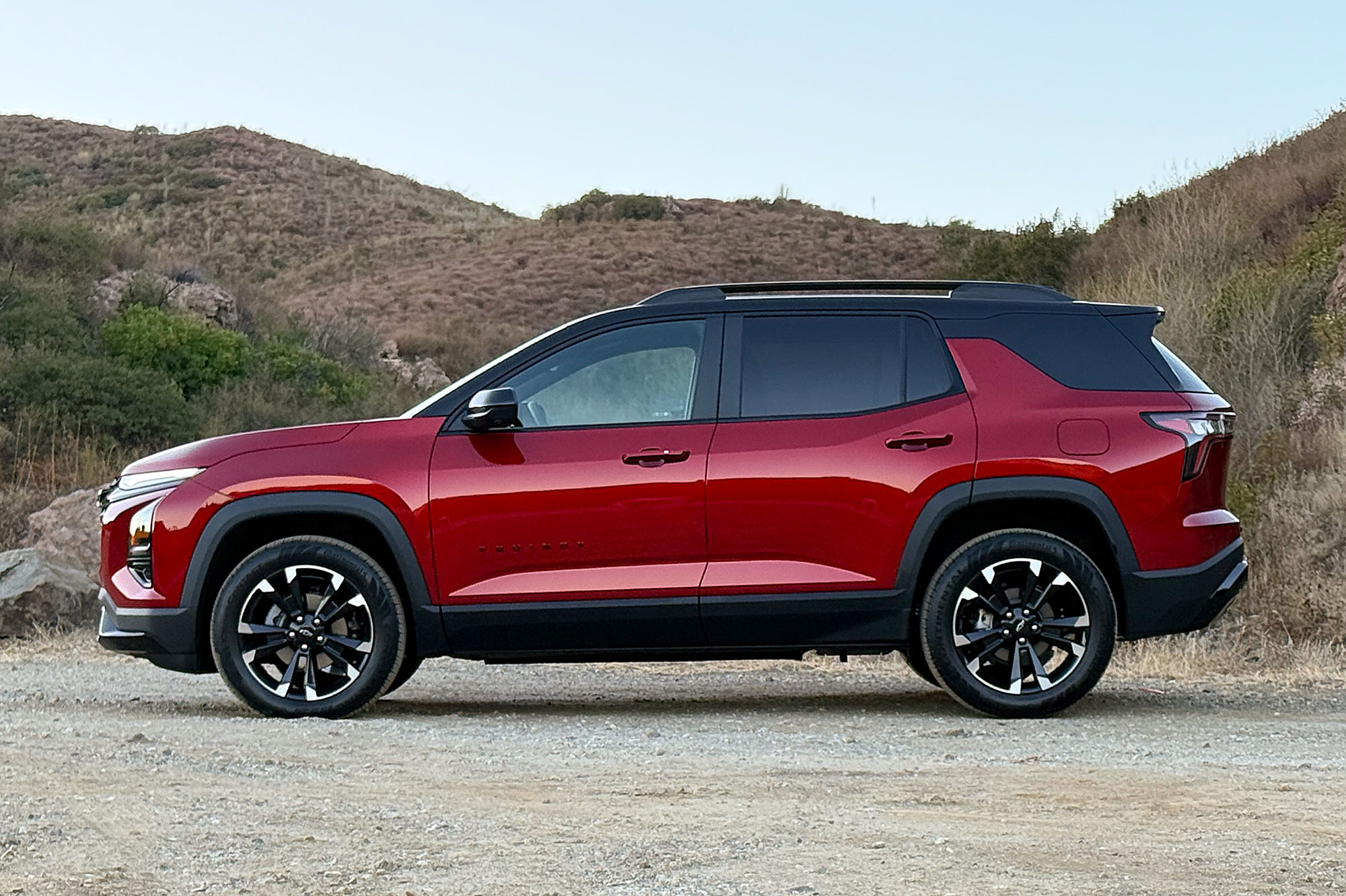 2025 Chevrolet Equinox RS in Radiant Red with mountains and blue sky in the background.