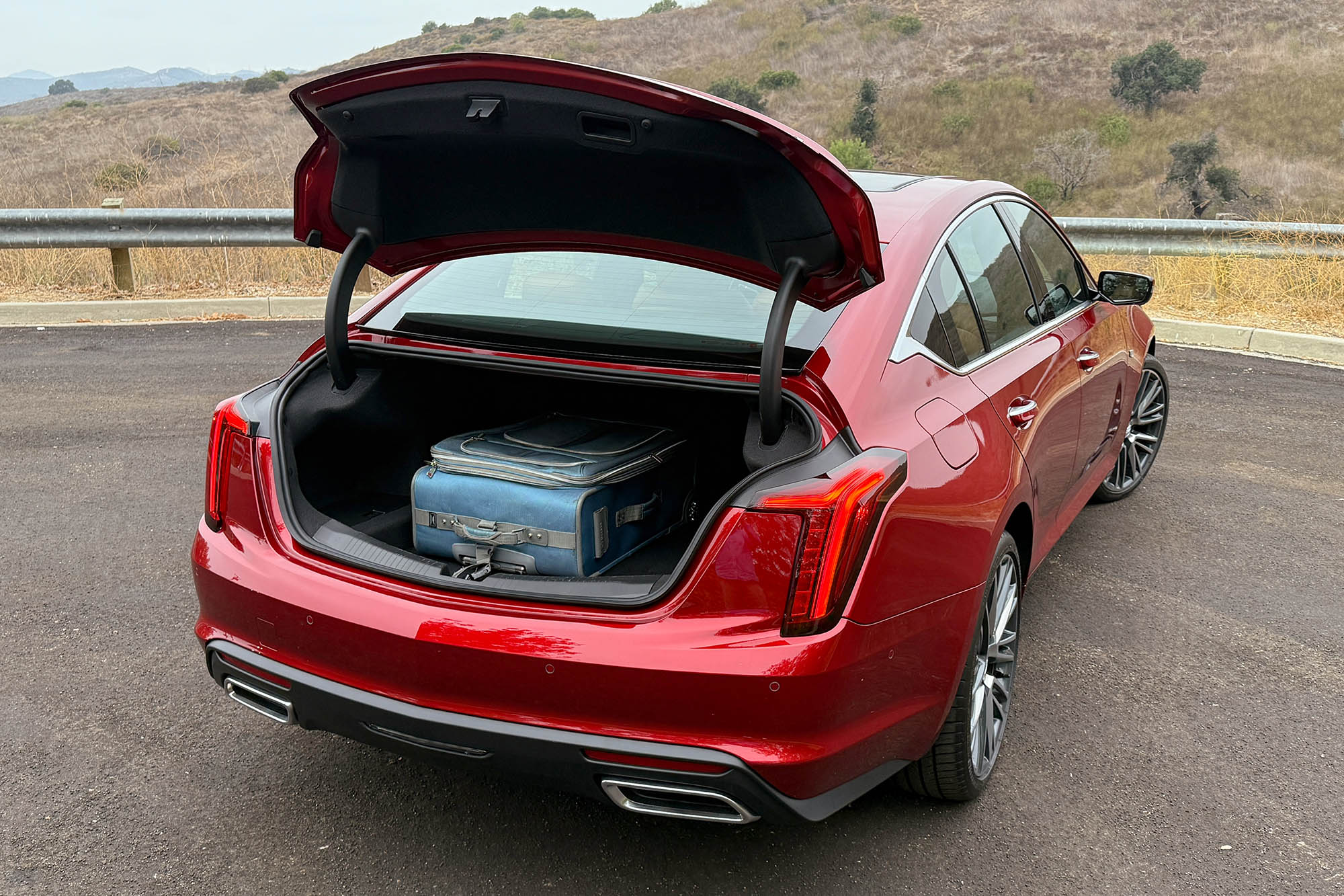 2025 Cadillac CT5 Premium Luxury in Radiant Red showing a full-size suitcase in the trunk