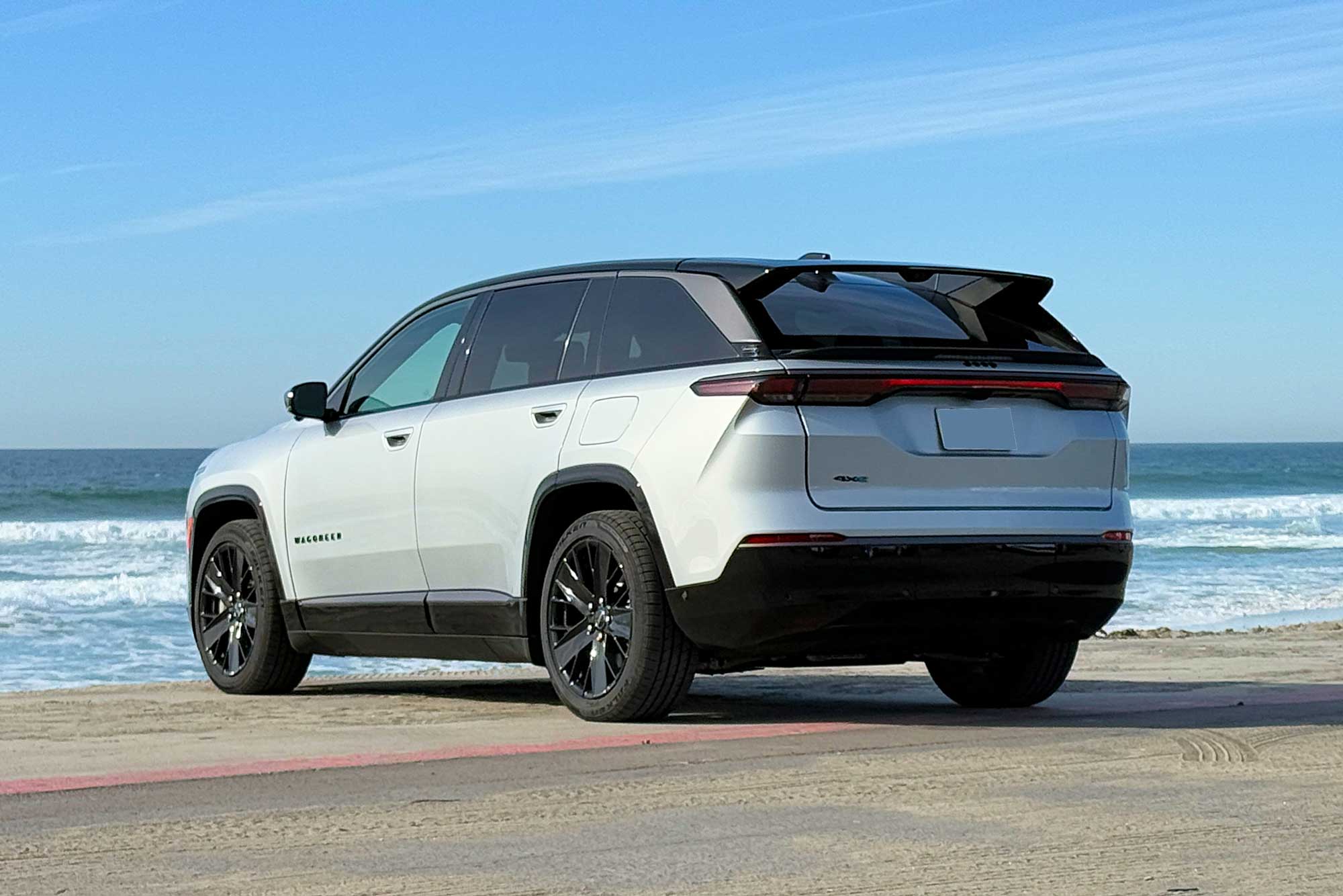 2024 Jeep Wagoneer S Launch Edition in Silver Zynith parked at a beach with the ocean and blue sky in the background.