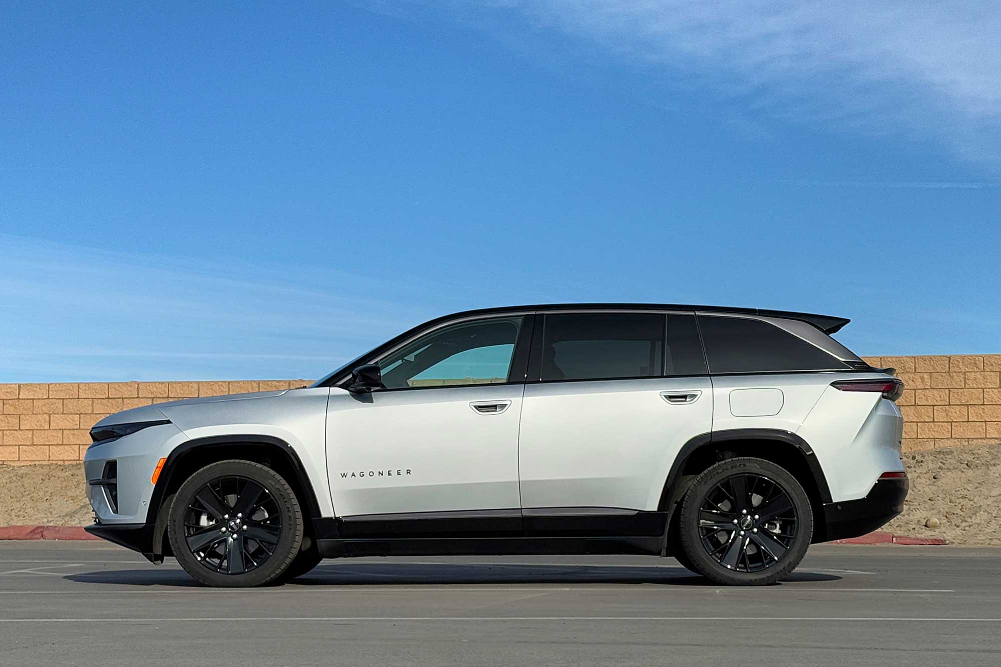 2024 Jeep Wagoneer S Launch Edition in Silver Zynith with a brick wall and blue sky in the background.