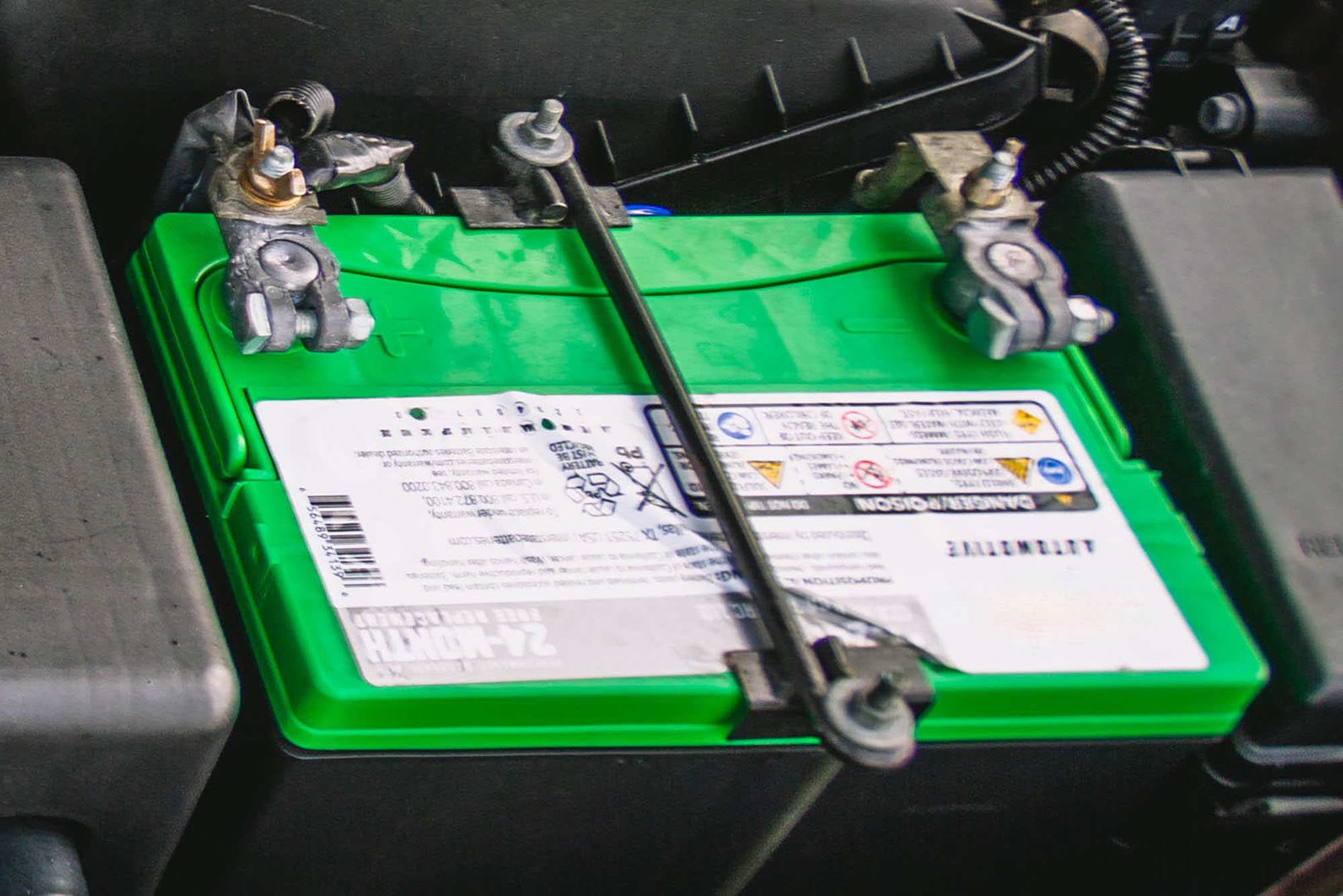 Battery clamped into a car's engine bay