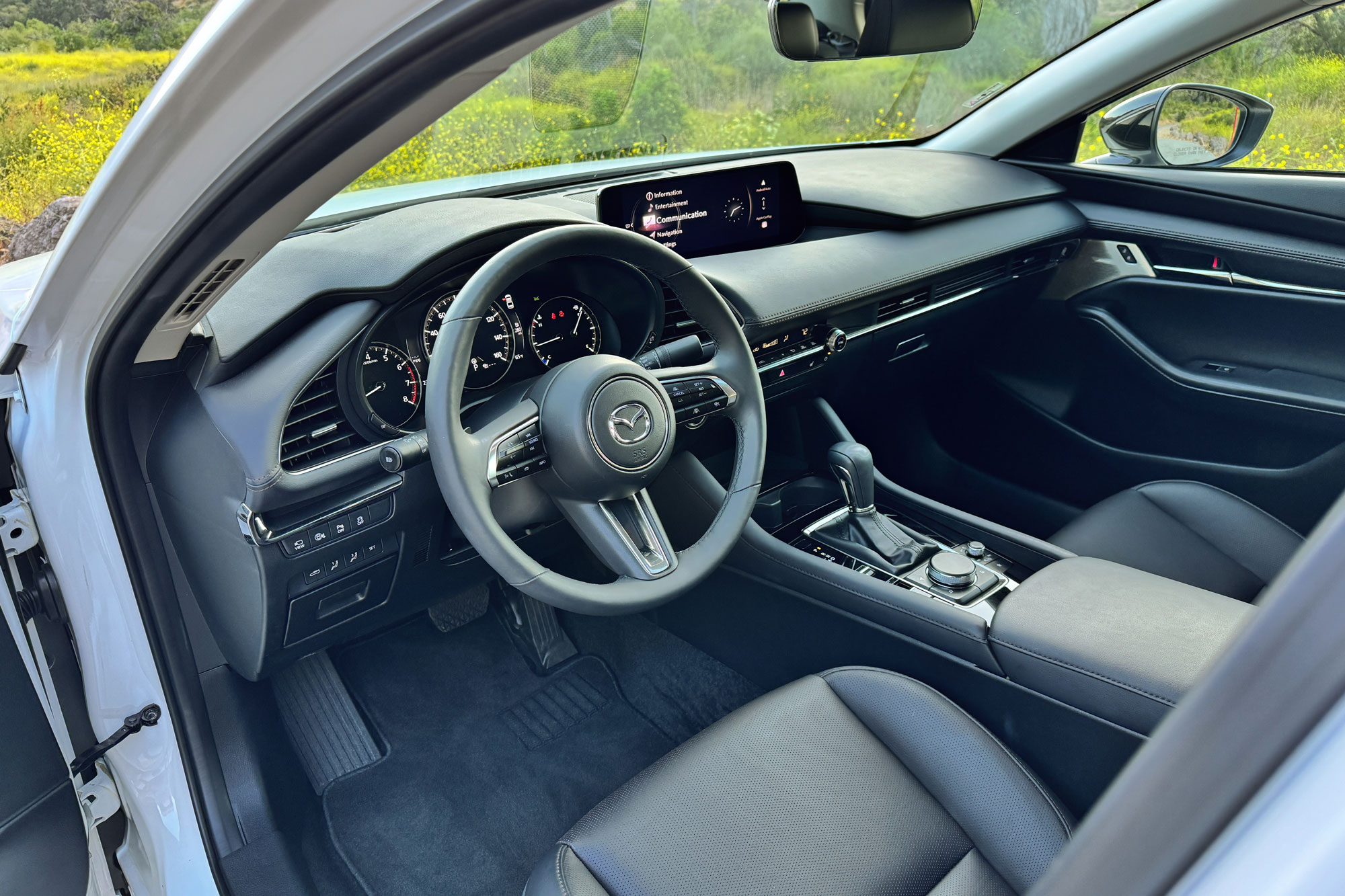 View of a 2024 Mazda 3 2.5 Turbo Premium Plus interior showing the dashboard and black leather front seats.