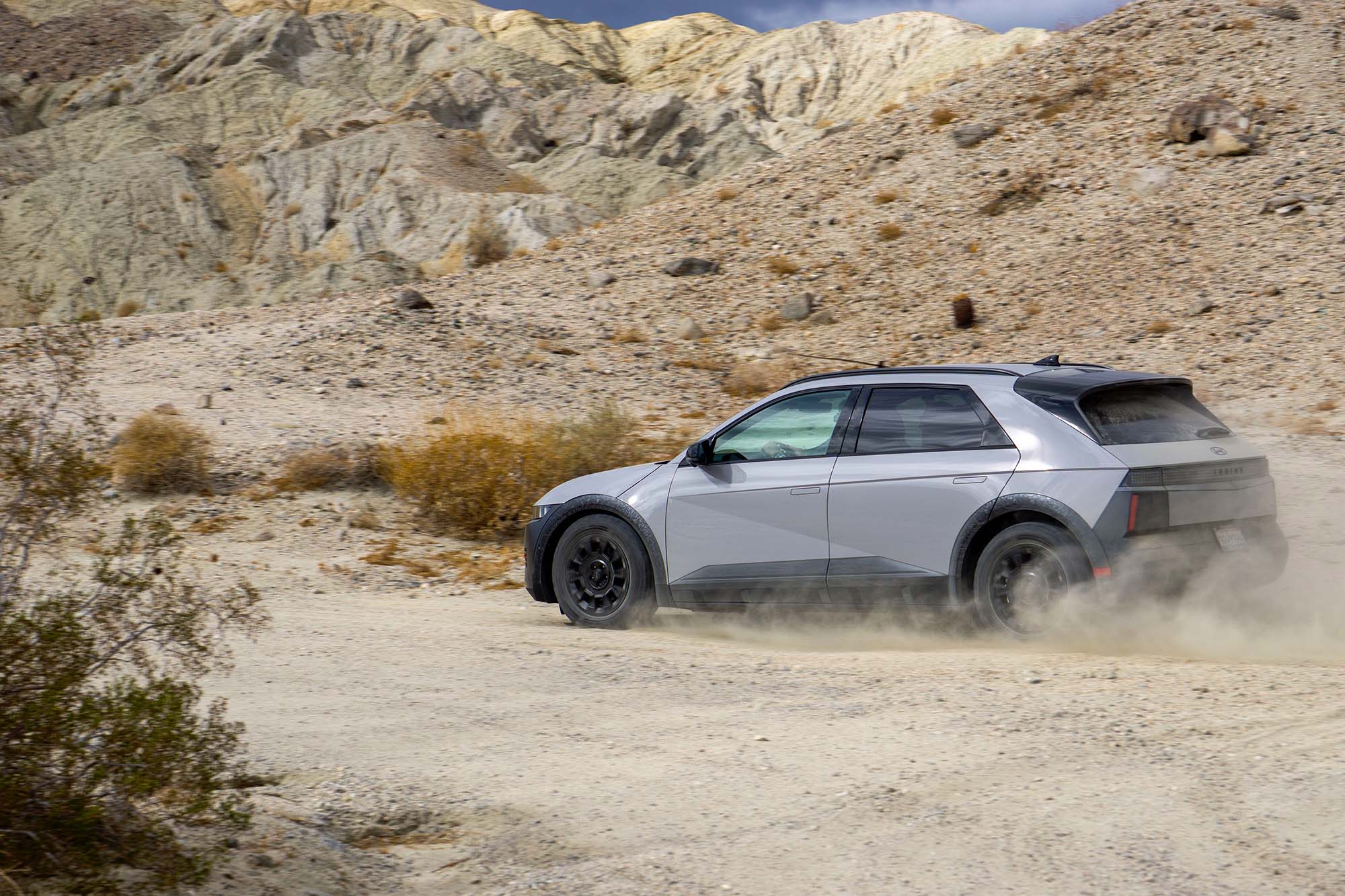 2025 Hyundai Ioniq 5 XRT in Cyber Gray churning through sand in the desert.