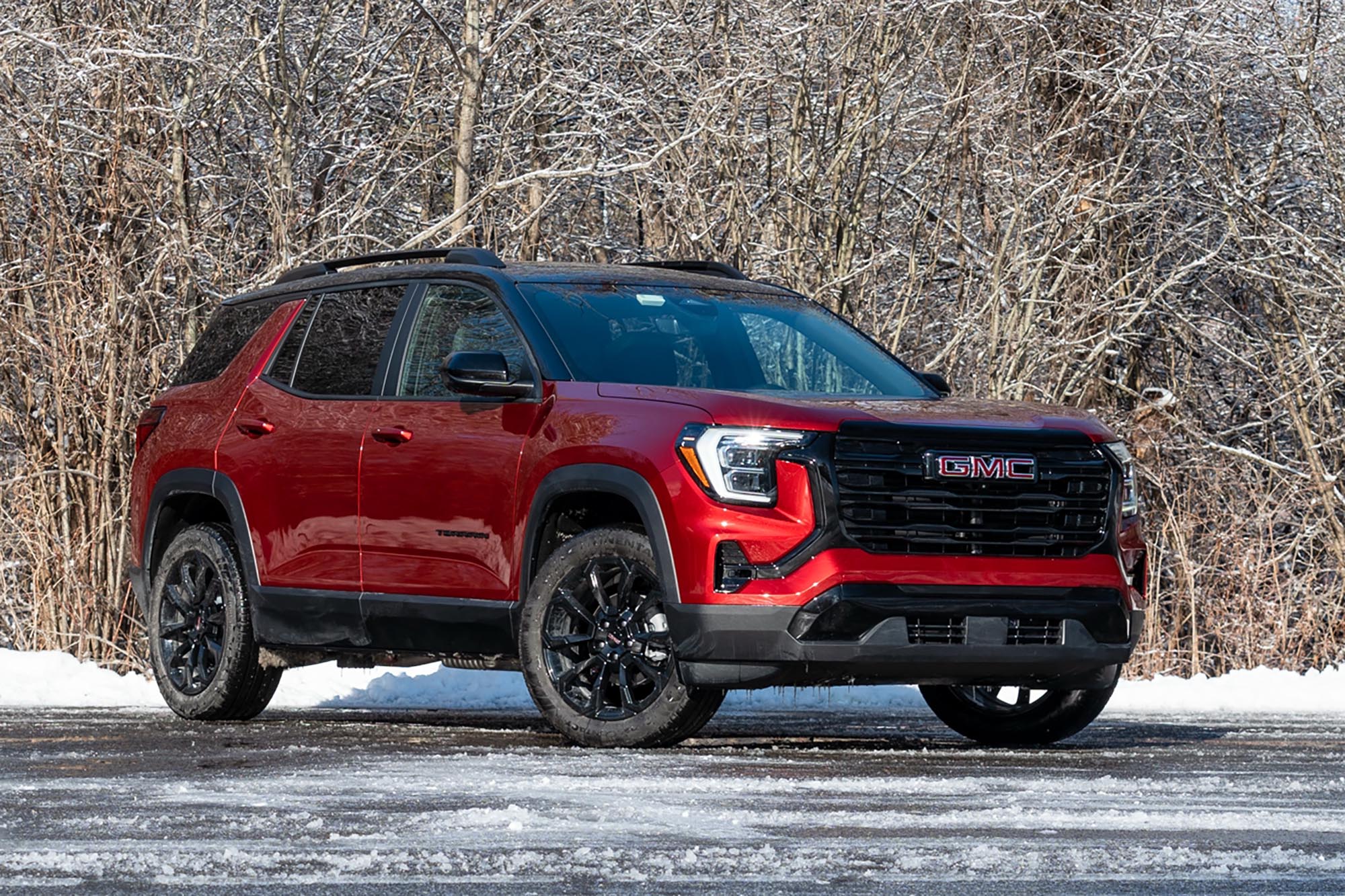 2025 GMC Terrain Elevation in Volcanic Red with snow and trees in the background.