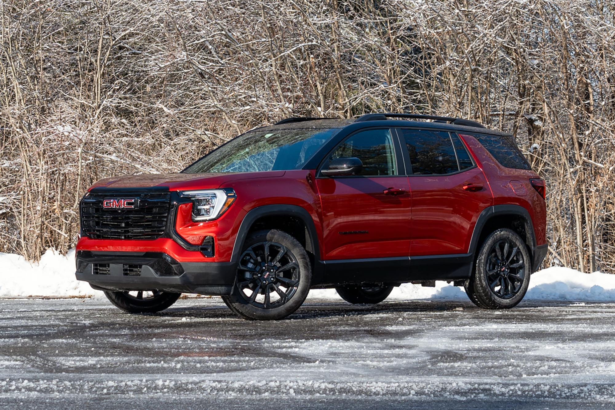 2025 GMC Terrain Elevation in Volcanic Red with snow and trees in the background.