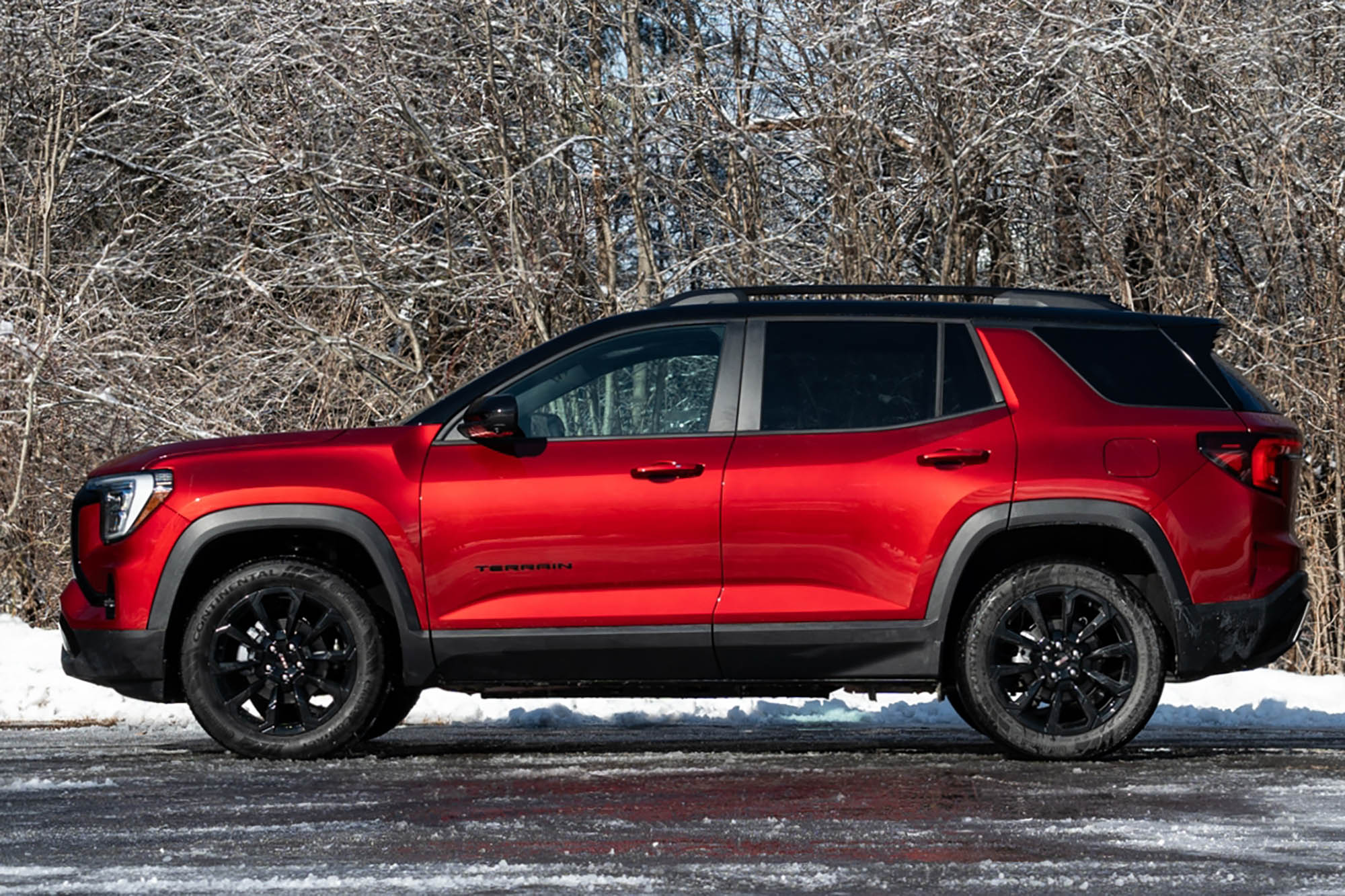 2025 GMC Terrain Elevation in Volcanic Red with snow and trees in the background.