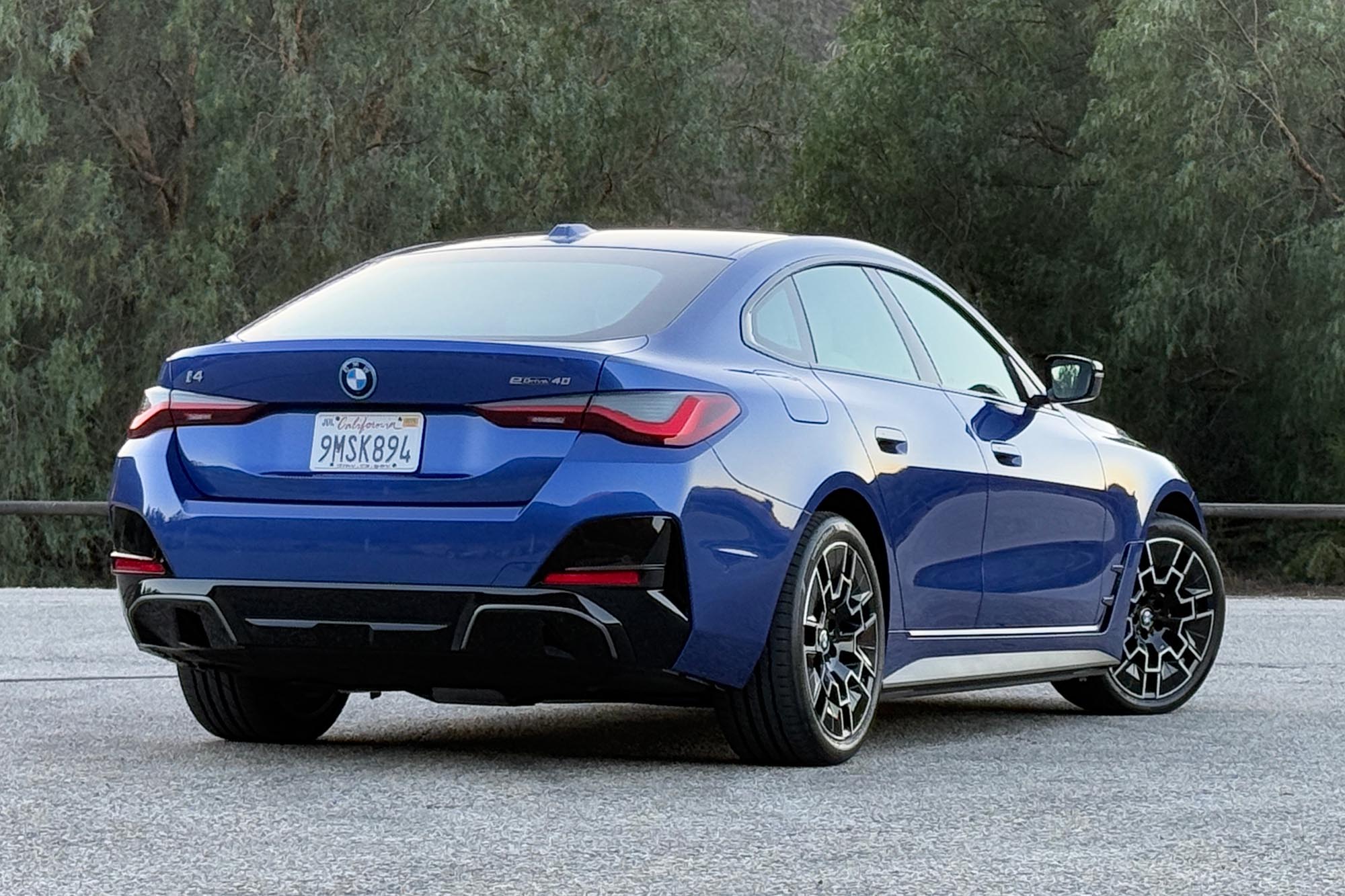 2025 BMW i4 eDrive40 in Portimao Blue with trees in the background.