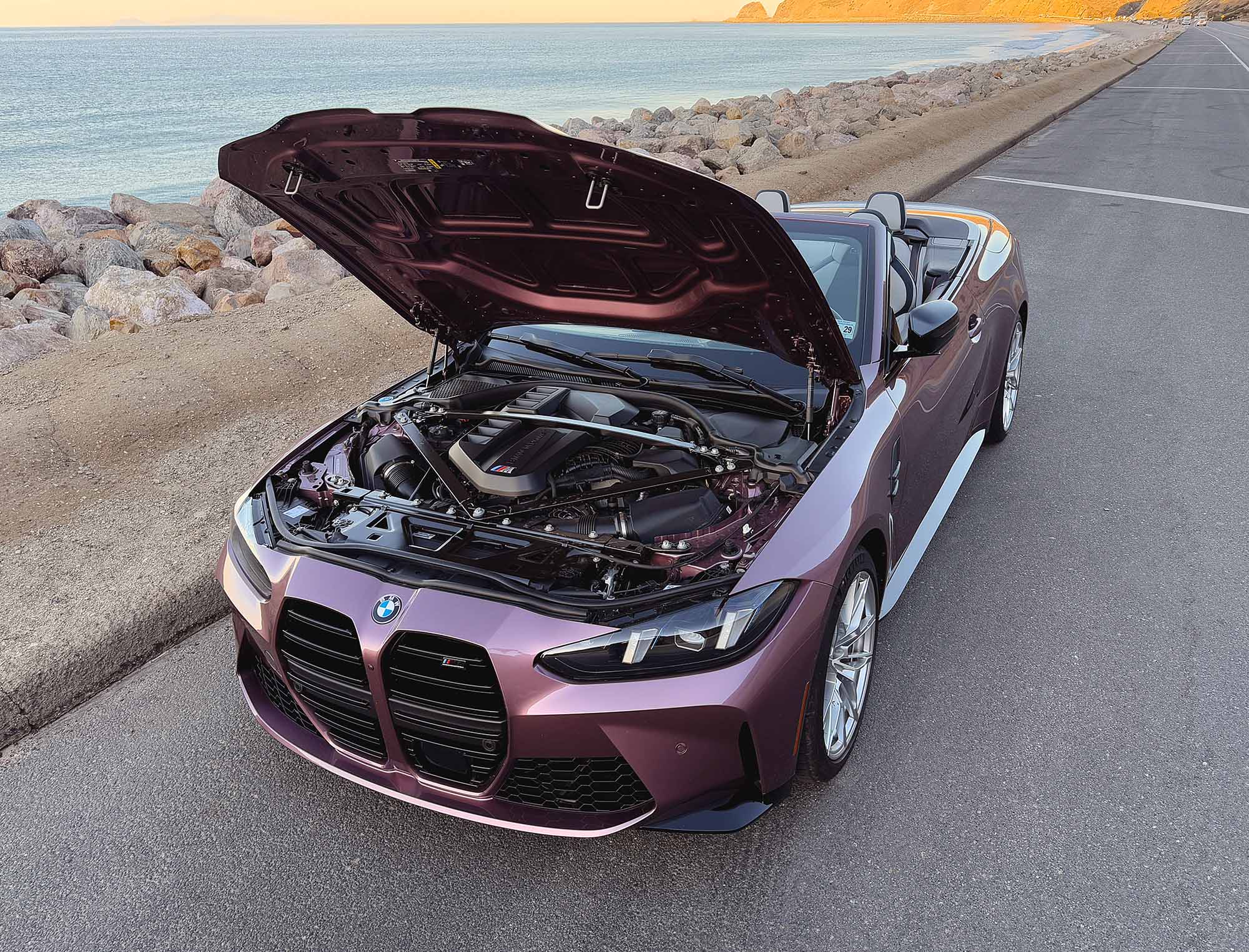 2025 BMW M4 Competition xDrive Convertible in Velvet Orchid with hood open showing engine bay