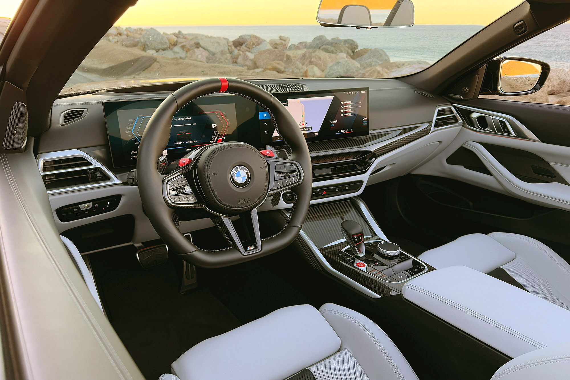 2025 BMW M4 Competition xDrive Convertible interior showing the dashboard with ocean in the background