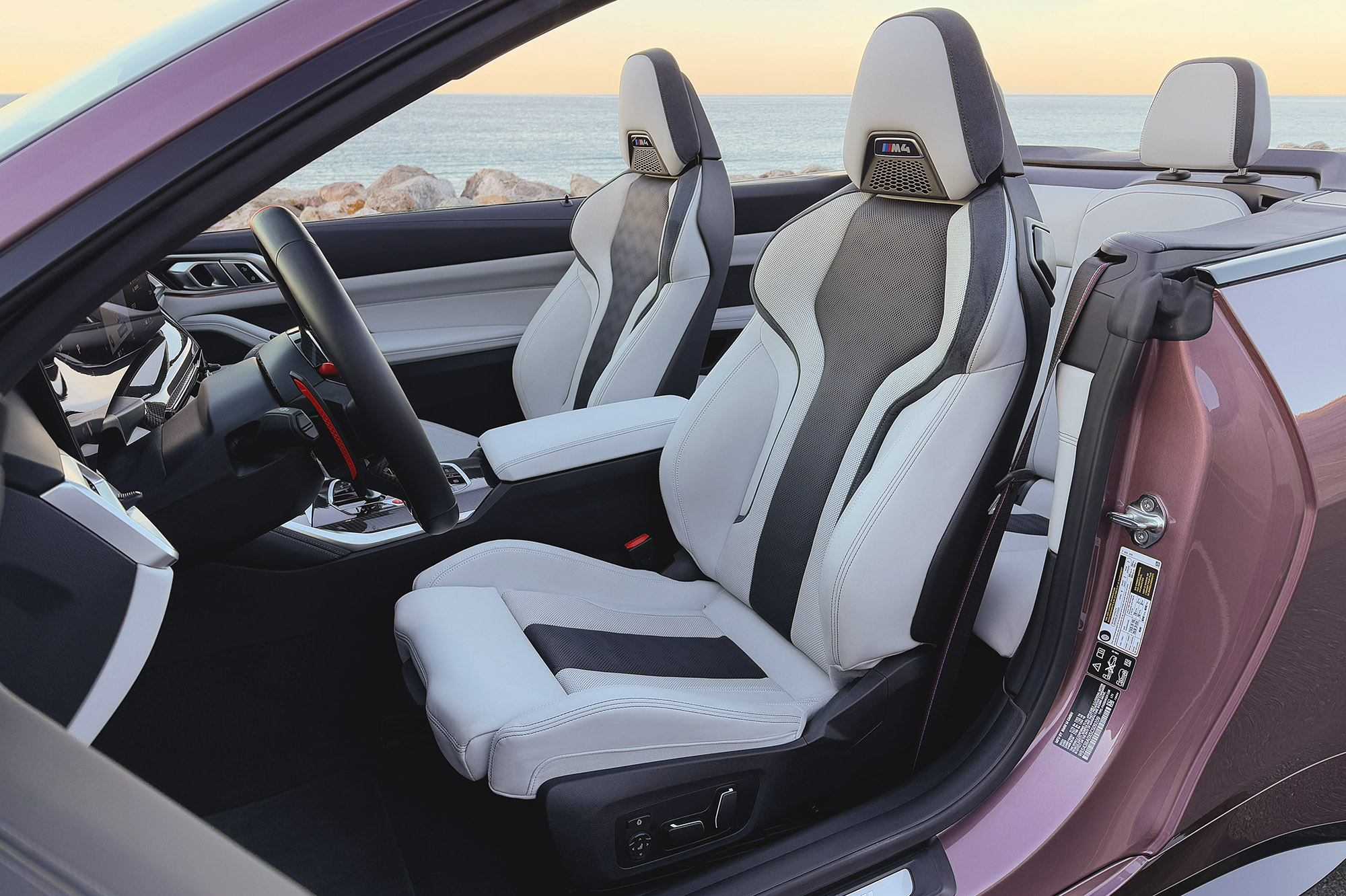 2025 BMW M4 Competition xDrive Convertible interior, front seats with ocean in the background